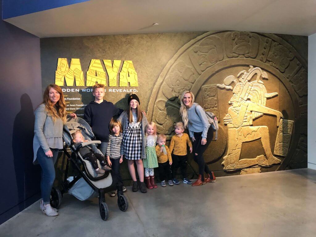 Kids and Adults posing in the Natural History Museum of Utah